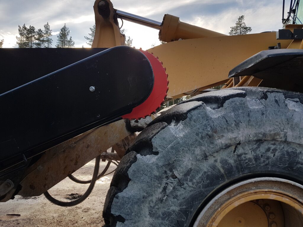 Bild på den mekaniska sandspridarens drivning som läggs an mot hjulet på lastaren