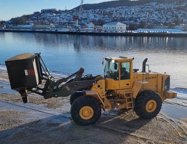 Bulkskopa på Hjullastare vid fyllning av bulkbil bredvid en hamn